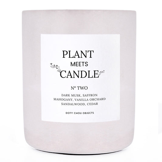 A light grey concrete candle vessel labelled as Plant Meets Candle No. Two.