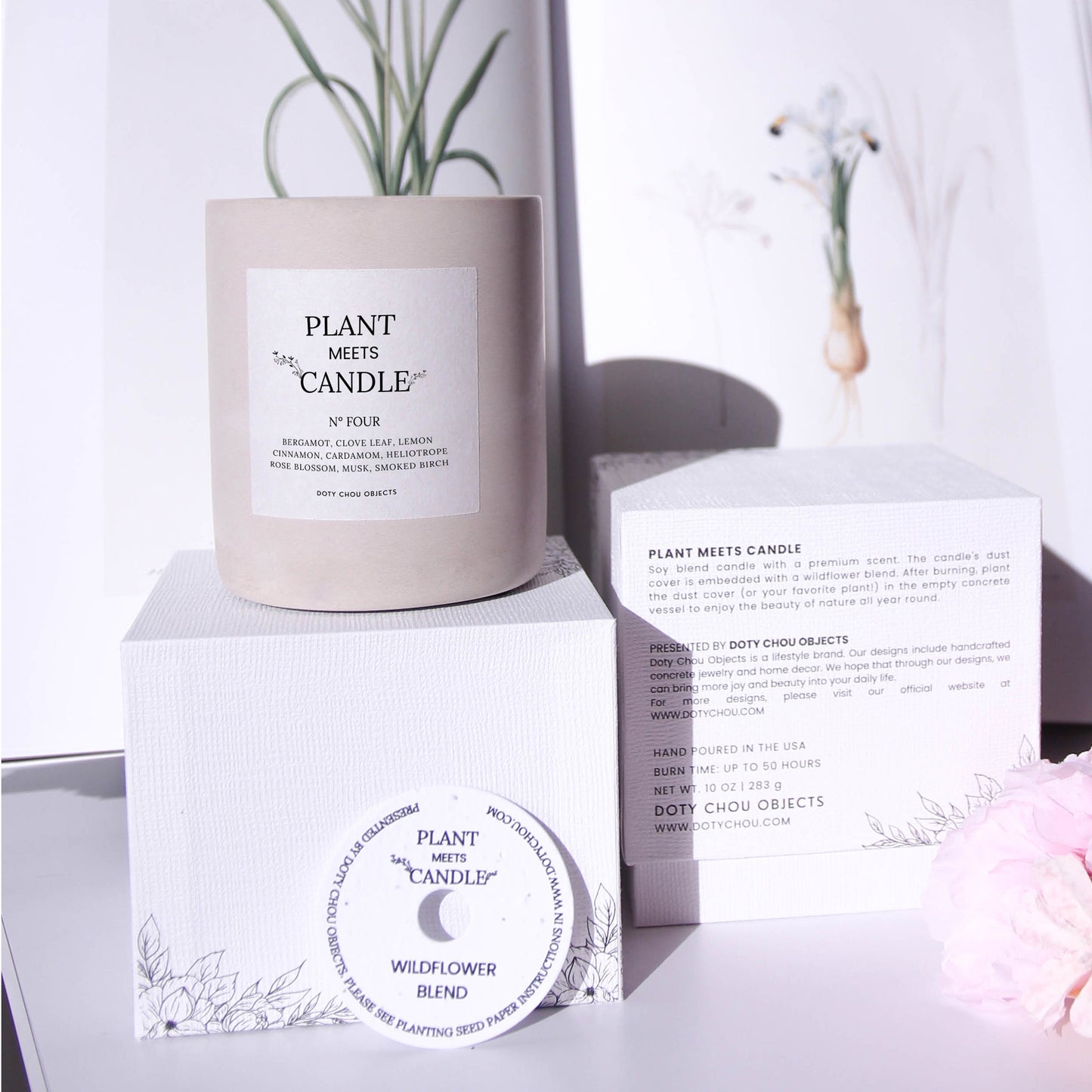 A light grey concrete vessel containing Plant Meets Candle No. Four displayed with botanical images alongside its product box and seed paper dustcover.